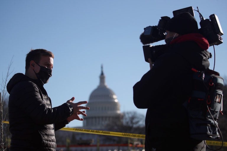 A TV journalist reports outside the Capitol Building where US National Guard troops have been deployed, Washington, DC, 19 January 2021, Yegor AleyevTASS via Getty Images