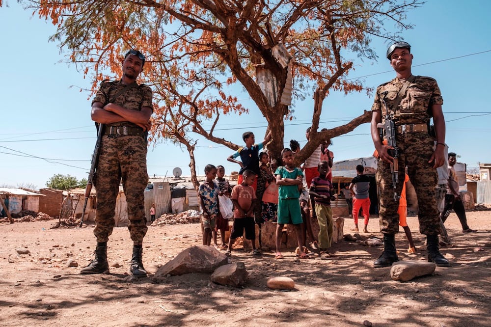 Éthiopie, le 30 janvier 2021. Des soldats de l'armée éthiopienne devant un groupe d'enfants au camp de réfugiés de Mai Aini pour réfugiés érythréens en plein conflit au Tigray. EDUARDO SOTERAS / AFP via Getty Images