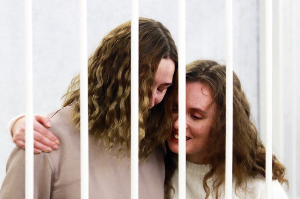 Belsat TV journalists Catarina Andreeva (R) and Darja Chulcova (L), who were detained in November while reporting on anti-government protests, embrace each other in a defendants' cage before the start of their trial, Minsk, Belarus, 9 February 2021, STRINGER/AFP via Getty Images