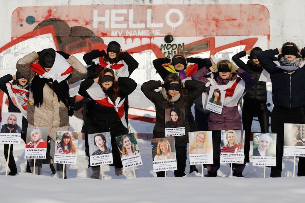 Blindfolded activists hold photographs of women imprisoned after the August 2020 presidential elections, as they protest against police violence, in Minsk, Belarus, 16 January 2021, STRINGER/AFP via Getty Images