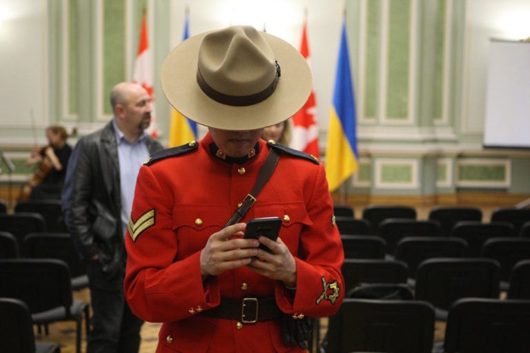 An RCMP officer browses a smartphone during a reception in honour of the Canadian Police Mission in Ukraine, in Kyiv, 5 March 2020, Yevhen Kotenko/ Ukrinform/Barcroft Media via Getty Images