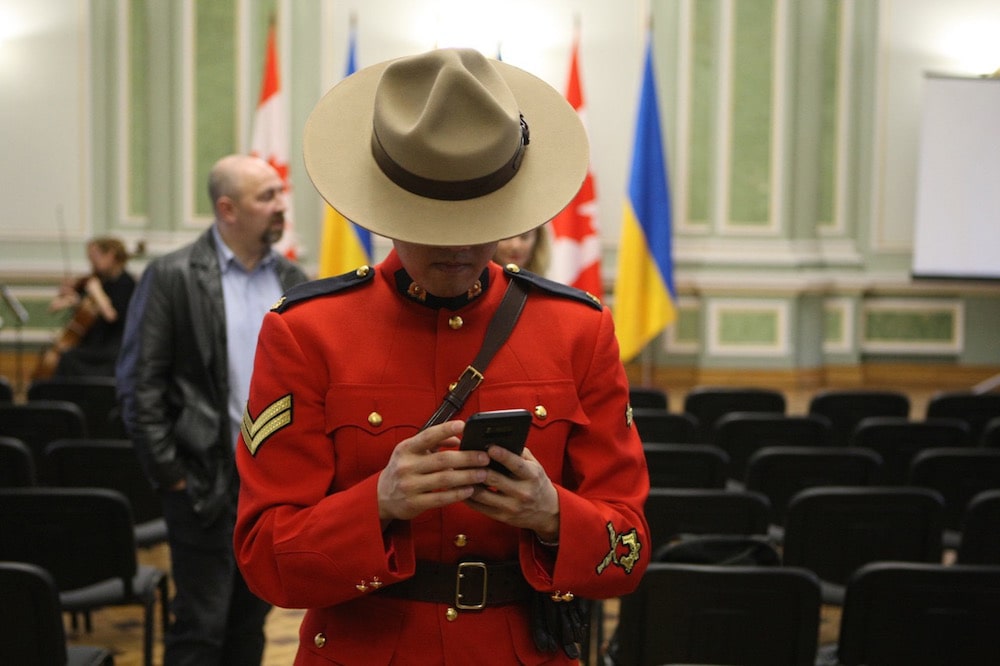 An RCMP officer browses a smartphone during a reception in honour of the Canadian Police Mission in Ukraine, in Kyiv, 5 March 2020, Yevhen Kotenko/ Ukrinform/Barcroft Media via Getty Images
