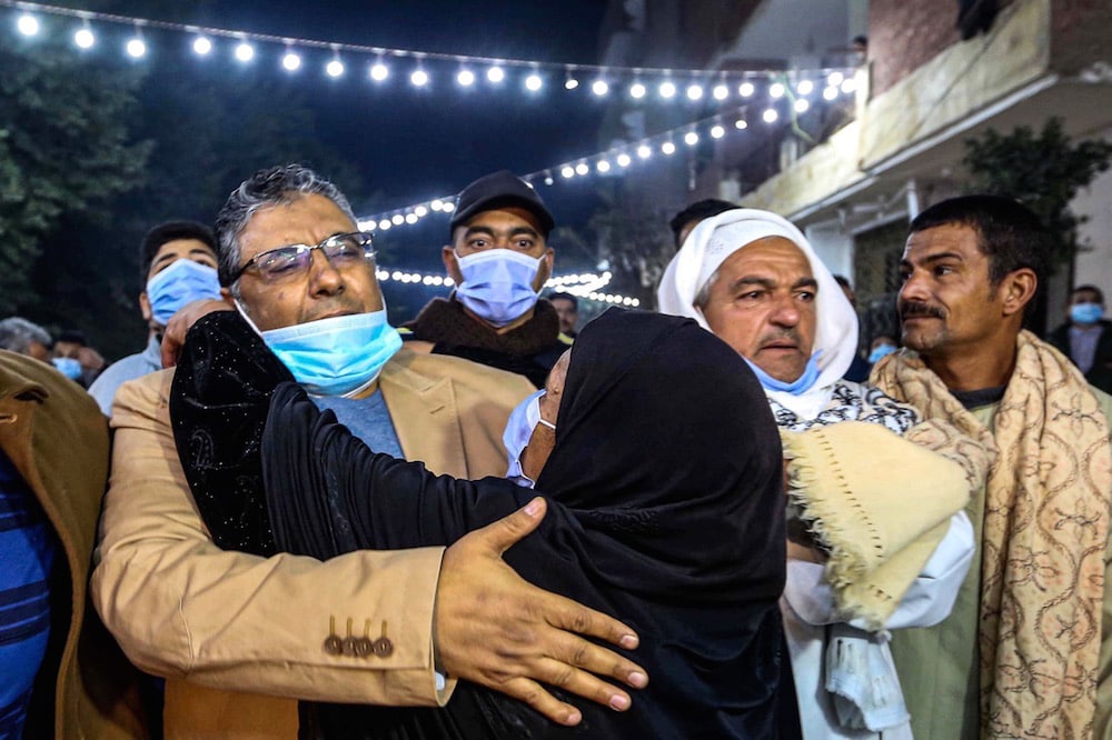 Al Jazeera journalist Mahmoud Hussein (L) is embraced by a woman upon his arrival at his family home in the Giza village of Zawyet Abu Musallam, Egypt, 6 February 2021, -/AFP via Getty Images