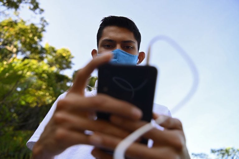 Un joven mira a su teléfono durante la pandemia de Covid-19, en Huizucar, El Salvador, el 18 de agosto de 2020, MARVIN RECINOS/AFP via Getty Images