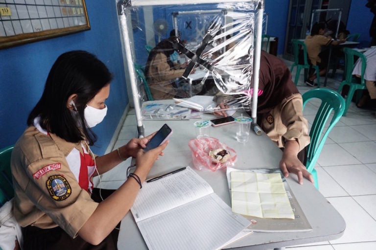 Students wear masks while studying remotely using a free internet network provided by residents of a pavillion, Central Jakarta City, Indonesia, 2 September 2020, Arya Manggala / Opn Images/Barcroft Media via Getty Images