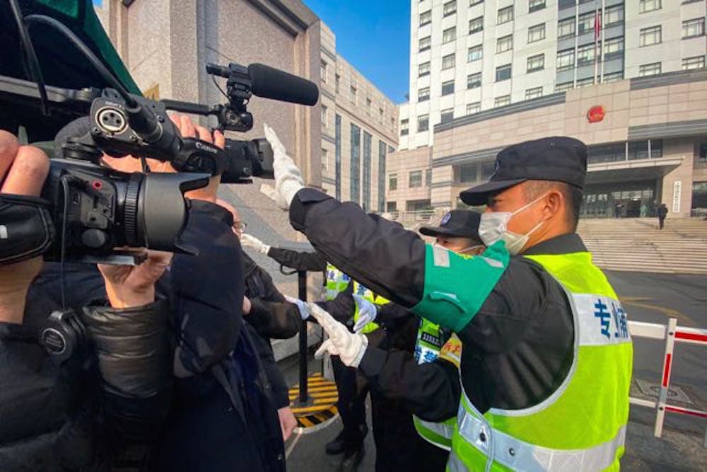 A policeman covers a camera to stop journalists from recording footage outside a court, where detained citizen journalist Zhang Zhan - who reported on Wuhan's Covid-19 outbreak - was set to go on trial, Shanghai, China, 28 December 2020, LEO RAMIREZ/AFP via Getty Images