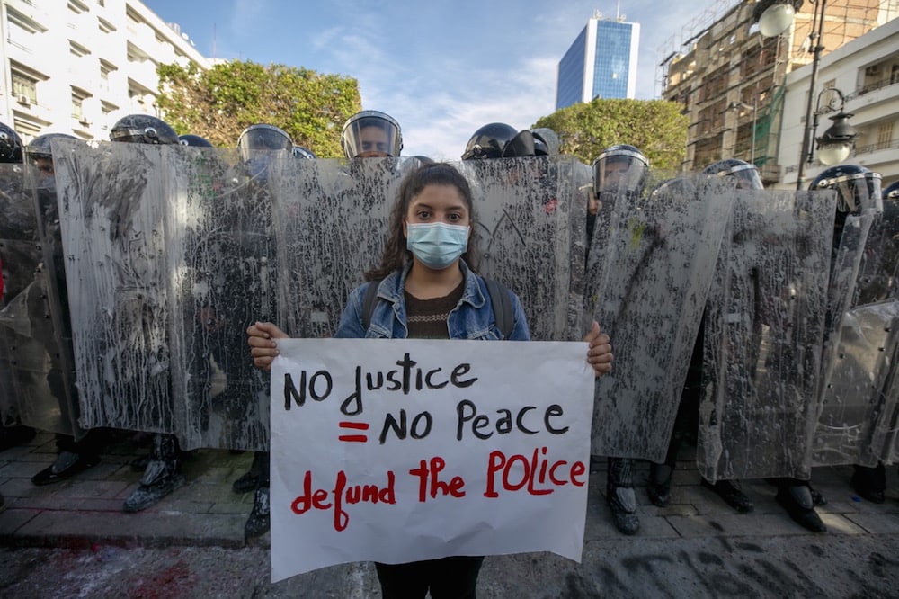 A young woman in front of a line of riot police during a demonstration against police repression and calling for the release of recently detained protesters, Tunis, Tunisia, 30 January 2021, Yassine Gaidi/Anadolu Agency via Getty Images