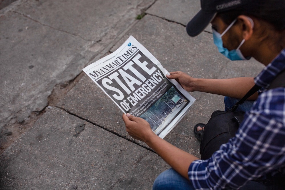 A man wearing a face mask reads a copy of the "Myanmar Times" paper with the headline 'State of Emergency', in Yangon, Myanmar, 2 February 2021, Aung Kyaw Htet/SOPA Images/LightRocket via Getty Images
