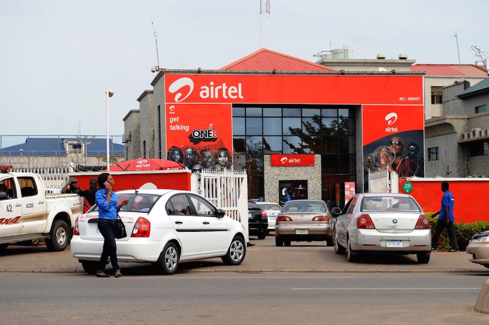 A woman makes a phone call in front of an Airtel office, one of Nigeria's main mobile Internet operators, in Abuja, 10 October 2011, PIUS UTOMI EKPEI/AFP via Getty Images