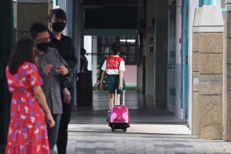 A primary school student pulling a school bag arrives at their school during the COVID-19 pandemic, in Singapore, 2 June 2020, Then Chih Wey/Xinhua via Getty