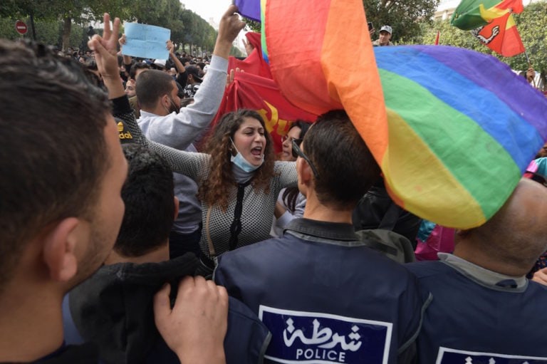 Protesters hold a rainbow flag while chanting slogans against the government and police repression, in Tunis, Tunisia, 6 February 2021, FETHI BELAID/AFP via Getty Images