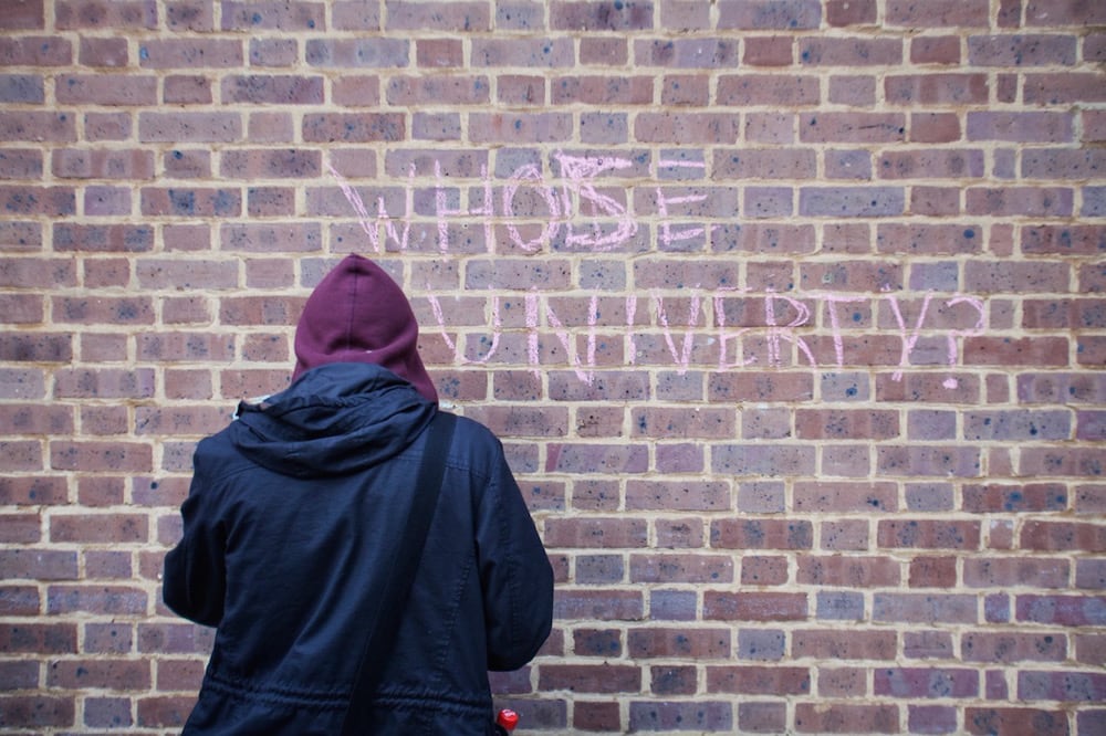 A protester uses chalk to write "Whose university" outside the University of London Union, 11 December 2013, during a campaign expressing concern over undercover police presence on campus. Andrea Baldo/LightRocket via Getty Images