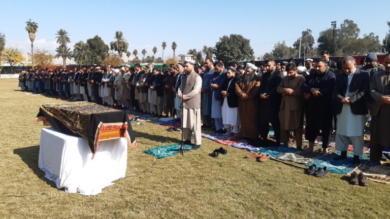 A photo depicting a crowd of mourners at the funeral of journalist Malalai Maiwand. Maiwands casket is also pictured in front of the crowd