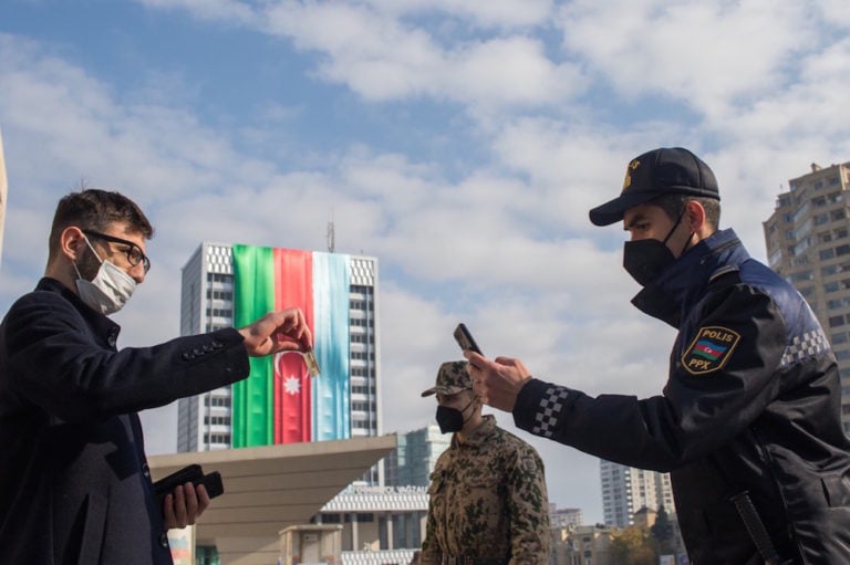 A police officer checks a man's permission to be on the street under measures implemented to fight Covid-19, Baku, Azerbaijan, 14 December 2020; Gambarov had commented on the mismanagement of the pandemic in Gandabay region. Aziz Karimov/Getty Images
