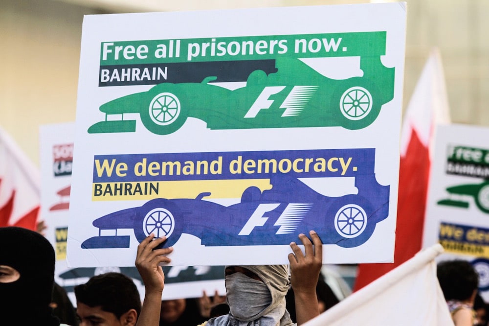 A group of protesters hold banners and placards demanding the cancellation of the Formula 1 race being held in Manama, Bahrain, as they stage an anti-government demonstration, 19 April 2015, Stringer/Anadolu Agency/Getty Images