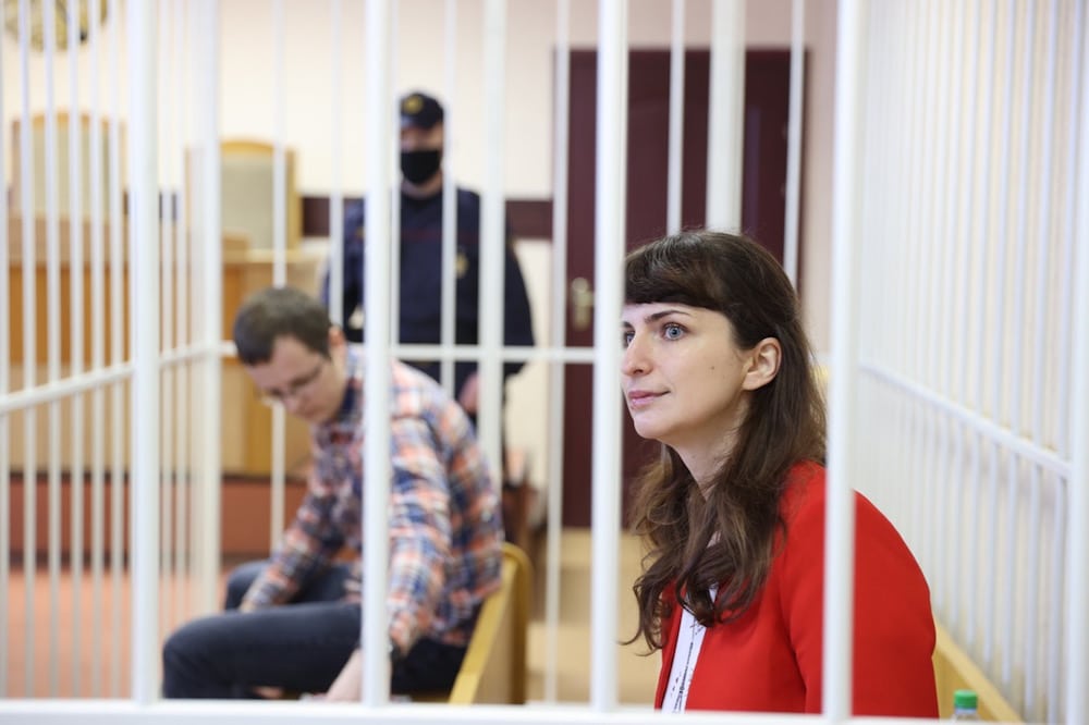 Katsiaryna Barysevich (R), journalist for the Tut.by website, and Artyom Sorokin (L, background), a doctor who is accused of releasing the deceased protester's medical information to the media, sit inside a defendant's cage during their trial in Minsk, Belarus, 19 February 2021, RAMIL NASIBULIN/BELTA/AFP via Getty Images