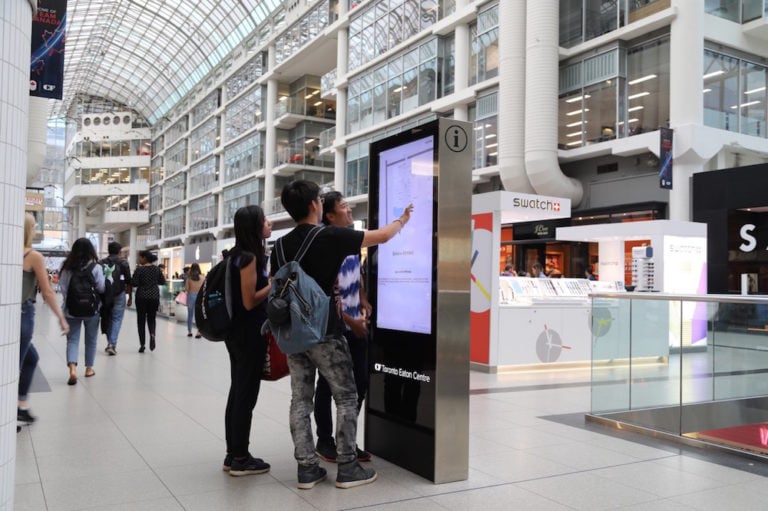 Shoppers use the interactive information map at the Eaton Centre shopping mall, Toronto, Canada, 26 July 2018; the parent company Cadillac Fairview uses facial recognition software embedded into many of the maps. Rene Johnston/Toronto Star via Getty Images