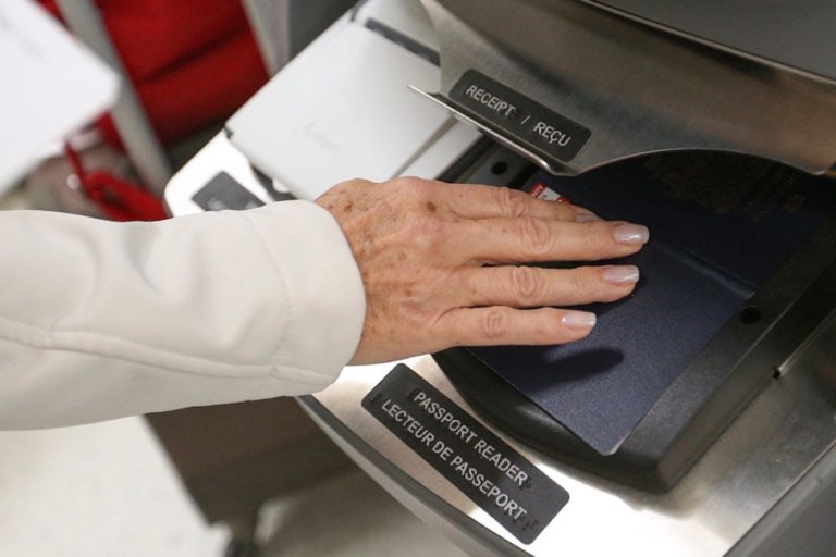 A woman scans her passport at an automated processing kiosk, at Pearson Airport, Toronto, Ontario, 4 December 2013, Richard Lautens/Toronto Star via Getty Images
