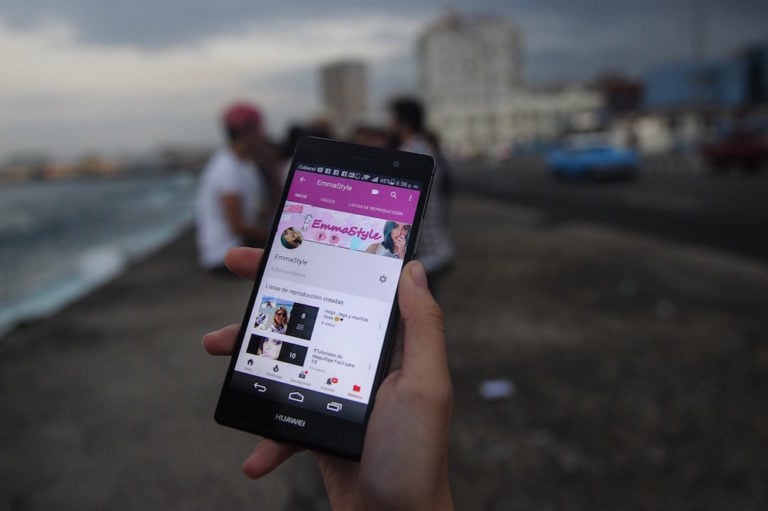 A Cuban blogger checks her channel on a cellphone at Havana's Malecon, Cuba, 27 February 2018, YAMIL LAGE/AFP via Getty Images