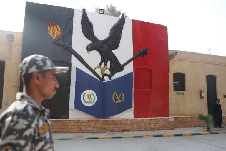 A picture taken during a guided tour organized by the Egyptian State Information Service shows a policeman walking in front of a mural in Tora prison, Cairo, 11 November 2019, MOHAMED EL-SHAHED/AFP via Getty Images