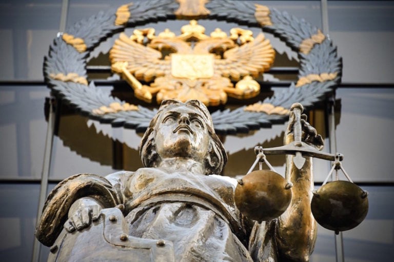 A statue of Themis, an ancient Greek Goddess of Justice, and a Russian national state emblem are seen at the entrance of Russia's Supreme Court in Moscow, 20 February 2021, the day that a court upheld a ruling to jail Alexei Navalny, ALEXANDER NEMENOV/AFP via Getty Images