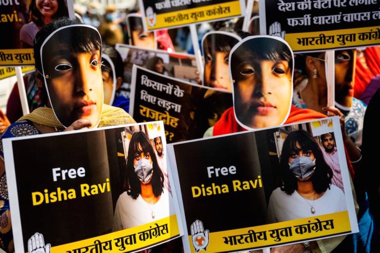 Demonstrators and Indian Youth Congress activists wear masks depicting environmental activist Disha Ravi, during a protest against her arrest and a recent fuel price hike, New Delhi, India, 22 February 2021, JEWEL SAMAD/AFP via Getty Images
