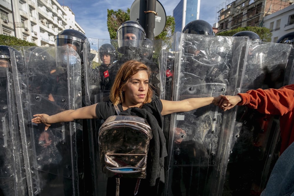 Tunisian protesters confront police officers forming a human shield to block access to the interior ministry, during a protest against "police repression" and calling for the release of recently detained demonstrators, in Tunis, 30 January 2021, Yassine Gaidi/Anadolu Agency via Getty Images