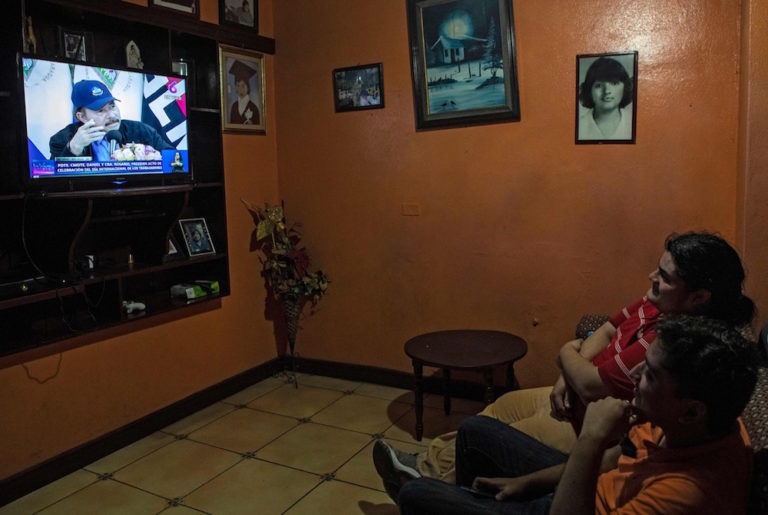 Two men watch TV while President Daniel Ortega gives a speech, in Managua, Nicaragua, 30 April 2020, INTI OCON/AFP via Getty Images
