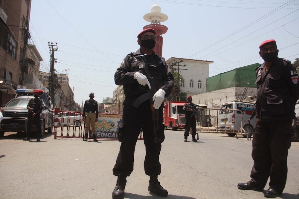 Security officials stand guard at a closed market during a lockdown in Sindh province due to COVID-19, Karachi, Pakistan, 10 April 2020, Sabir Mazhar/Anadolu Agency via Getty Images