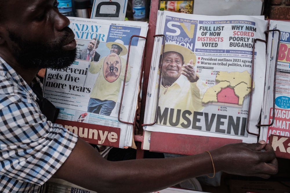 A vendor displays newspapers whose front pages show a portrait of re-elected President Yoweri Museveni, at a kiosk in Kampala, Uganda, 17 January 2021, YASUYOSHI CHIBA/AFP via Getty Images