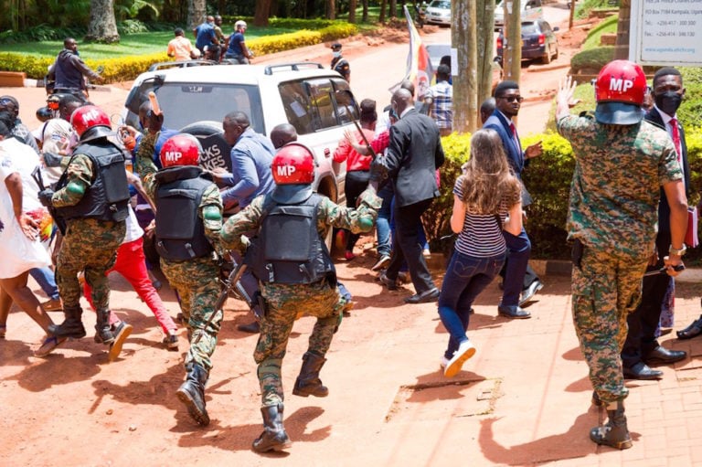 Supporters of opposition leader Robert Kyagulanyi, aka Bobi Wine, and local and foreign journalists are assaulted by Uganda Military Police, outside the UN Human Rights Office in Kampala, 17 February 2021, BADRU KATUMBA/AFP via Getty Images