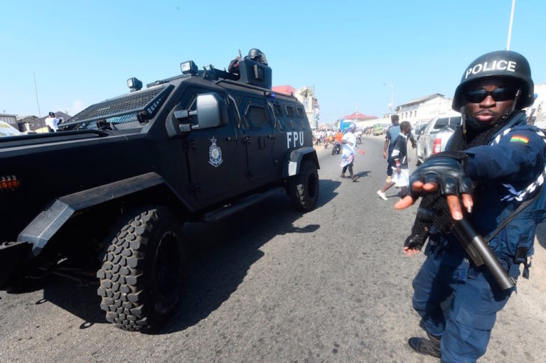 A policeman tries to stop people advancing toward an armoured personnel tank during the final day of election campaigning, Accra, Ghana, 5 December 2020, PIUS UTOMI EKPEI/AFP via Getty Images