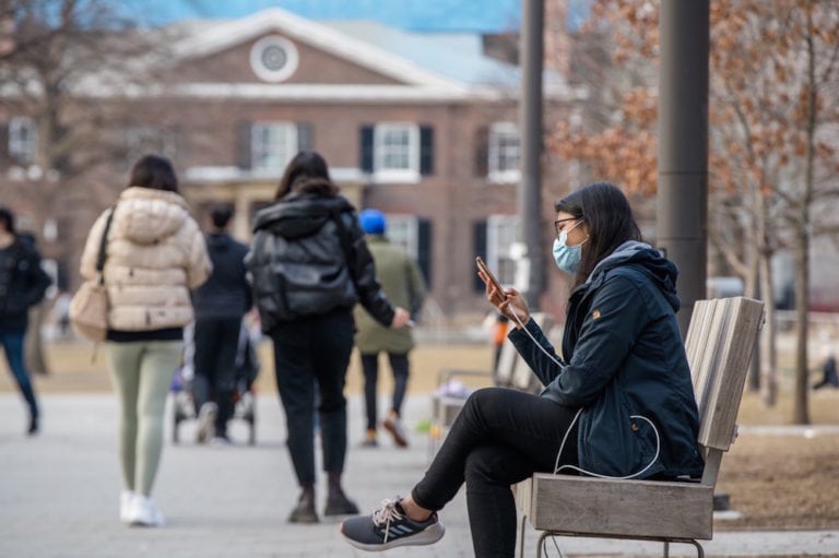 A woman wearing a mask looks at her cell phone in a park in Toronto, Canada, 17 March 2021, Shawn Goldberg/SOPA Images/LightRocket via Getty Images