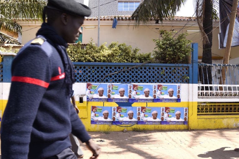 A fire fighter walks by a row of election posters for then presidential candidate Umaro Sissoco Embaló, in Bissau, Guinea-Bissau, 27 December 2019, SEYLLOU/AFP via Getty Images