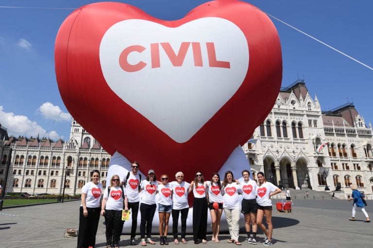 Members of leading NGOs pose in front of a heart-shaped balloon and call on MPs to not support a package of bills that would criminalise assisting asylum seekers, Budapest, Hungary, 4 June 2018, ATTILA KISBENEDEK/AFP via Getty Images