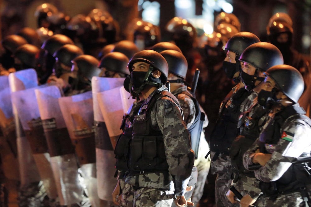 Members of Jordan's Darak forces (gendarmerie) stand on guard as protesters demonstrate against measures imposed to curb the spread of Covid-19 amidst concerns over the economy, in Amman, Jordan, 15 March 2021, KHALIL MAZRAAWI/AFP via Getty Images