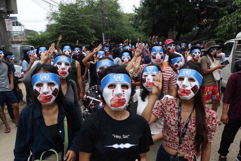 People wearing masks symbolising the silencing of dissent, stage a demonstration to protest against the military coup, Yangon, Myanmar, 4 April 2021, Stringer/Anadolu Agency via Getty Images