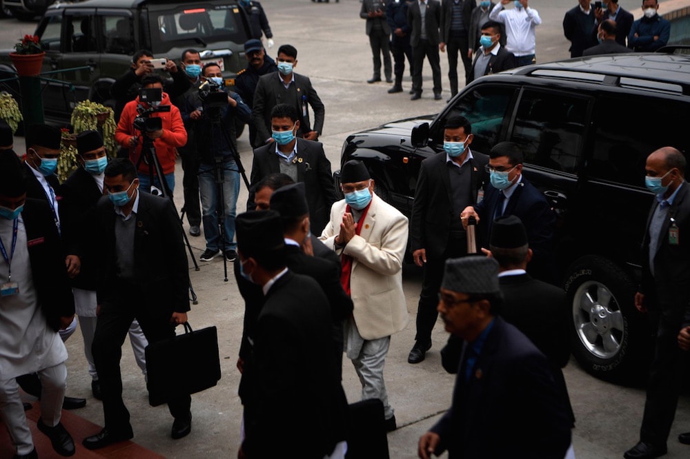 Journalists report on the scene as Prime Minister KP Sharma Oli (C) arrives to attend the first meeting of the House of Representatives, in Kathmandu, Nepal, 7 March 2021, PRAKASH MATHEMA/AFP via Getty Images
