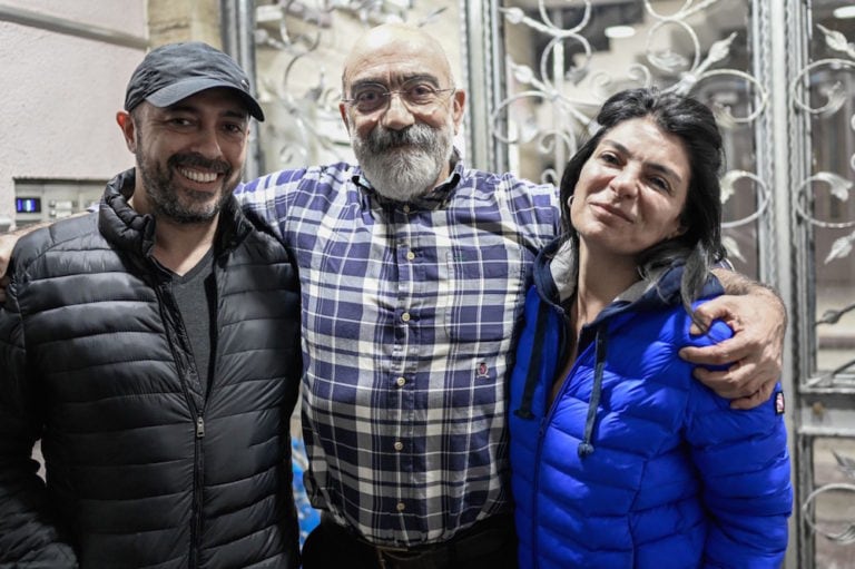 Turkish journalist and writer Ahmet Altan (C), with his children Kerem (L) and Senem (R), poses for AFP at his home minutes after he arrived following his release from jail, in Istanbul, Turkey, 14 April 2021, BULENT KILIC/AFP via Getty Images