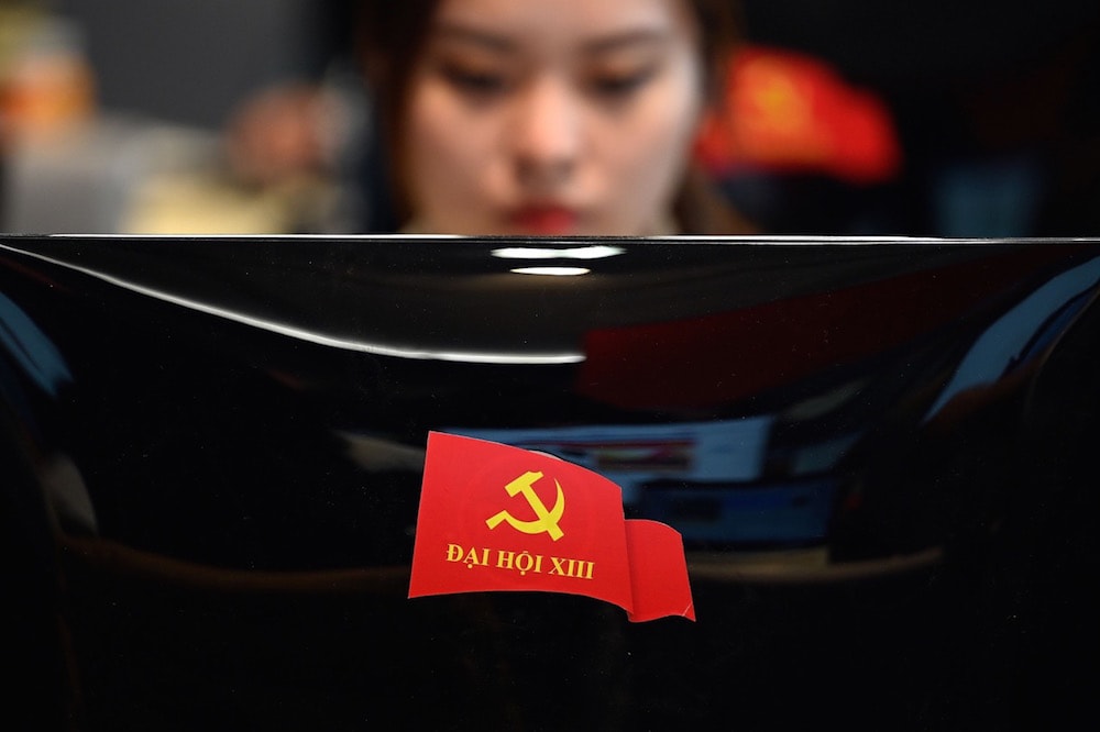 A sticker of the Communist Party of Vietnam (CPV) 13th National Congress is seen on the back of a journalist's computer monitor, Hanoi, Vietnam, 26 January 2021, MANAN VATSYAYANA/AFP via Getty Images