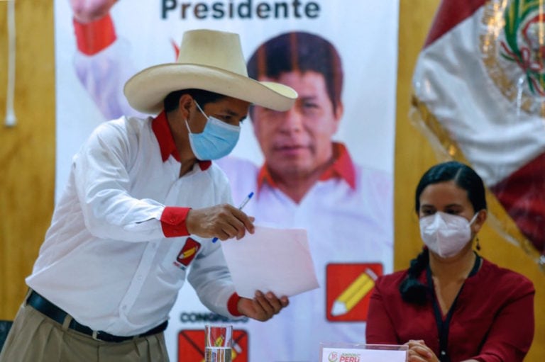 Lima, Peru, 5 May 2021. Peruvian presidential candidate Pedro Castillo (L) hands a document to former presidential candidate Veronika Mendoza, for her to sign pledging her support for Castillo in the 6 June election runoff, GIAN MASKO/AFP via Getty Images