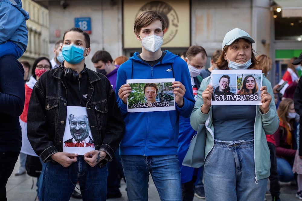 Protesters hold images of Belarus president Alexander Lukashenko (L), journalist Raman Pratasevich (C) and Pratasevich's Russian girlfriend Sofia Sapega (R) during a demonstration by Belarusians and Poles in Warsaw, Poland, 24 May 2021, WOJTEK RADWANSKI/AFP via Getty Images