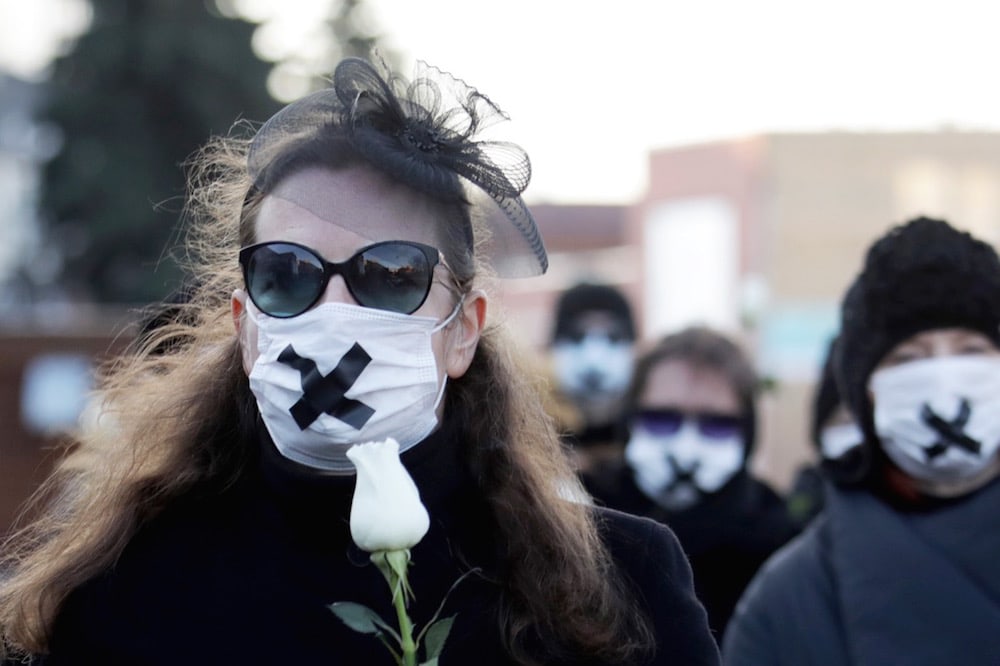 Women wearing black clothing and tape over their mouths demonstrate against the conviction of a journalist and a doctor over the disclosure of a protester's medical records, Minsk, Belarus, 2 March 2021, -/AFP via Getty Images