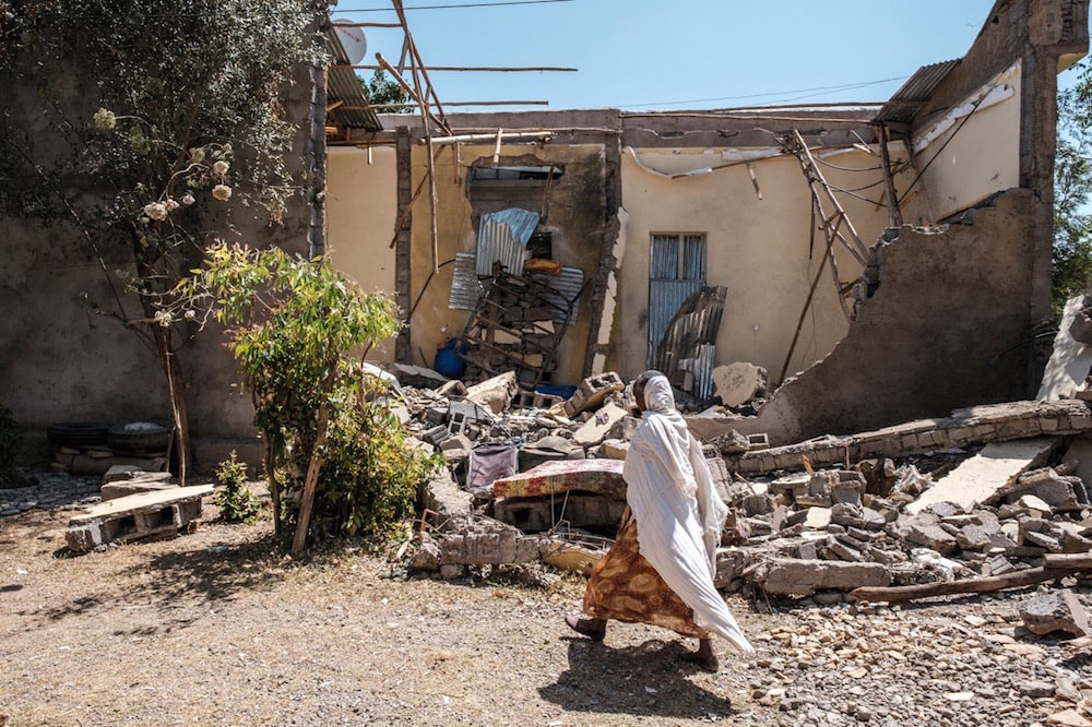 A woman walks by a house which was shelled, in Wukro, north of Mekele, Tigray , 1 March 2021; Ethiopia expelled reporter Simon Marks in connection with his reporting on Tigray. EDUARDO SOTERAS/AFP via Getty Images