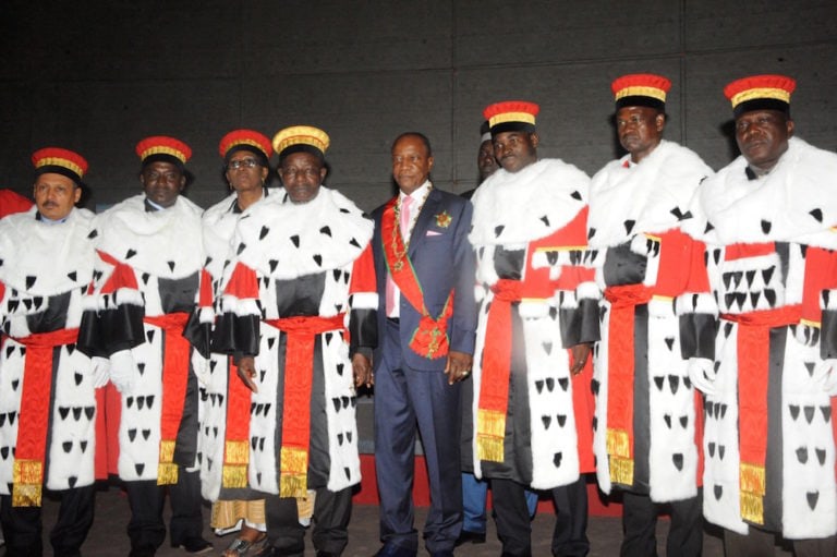 President Alpha Condé (C) poses with members of Guinea's Constitutional Court after his swearing in, in Conakry, 14 December 2015, CELLOU BINANI/AFP via Getty Images