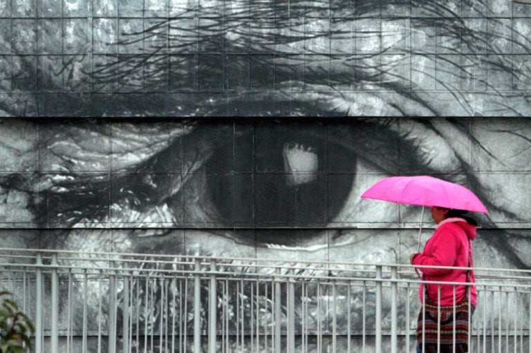 A woman walks past a mural depicting a 'seeing eye', in Los Angeles, California, 20 November 2011, Lawrence K. Ho/Los Angeles Times