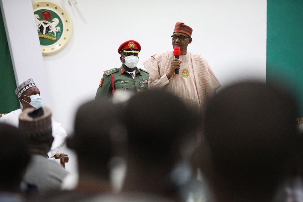 Nigeria's President Muhammadu Buhari (R) speaks during a meeting with schoolboys who had been abducted, upon their release in Katsina, 18 December 2020, KOLA SULAIMON/AFP via Getty Images