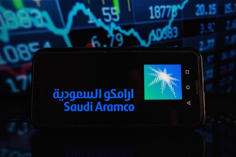 يعرض هذا الرسم التوضيحي شعار أرامكو السعودية على هاتف ذكي مع تقارير سوق الأسهم في الخلفية، 8 نيسان 2021. (الصورة من: عمر ماركيز / SOPA Images / LightRocket عبر Getty Images).