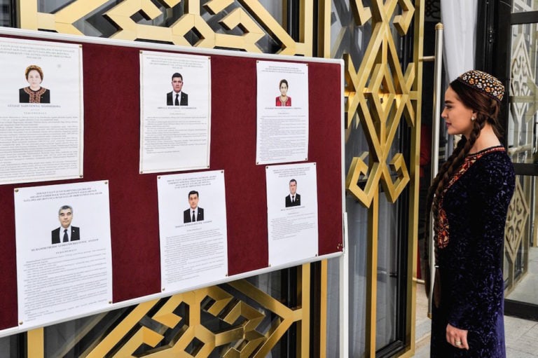 A woman looks at the profiles of candidates during parliamentary elections in Ashgabat, Turkmenistan, 25 March 2018, IGOR SASIN/AFP via Getty Images