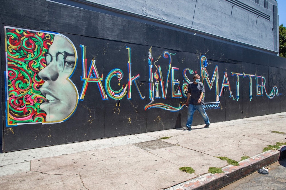 A man walks by a Black Lives Matter mural in Los Angeles, California, 24 May 2021, as activists call on the mayor and the City Council to pressure Congress to pass the Floyd Police Reform Bill, APU GOMES/AFP via Getty Images